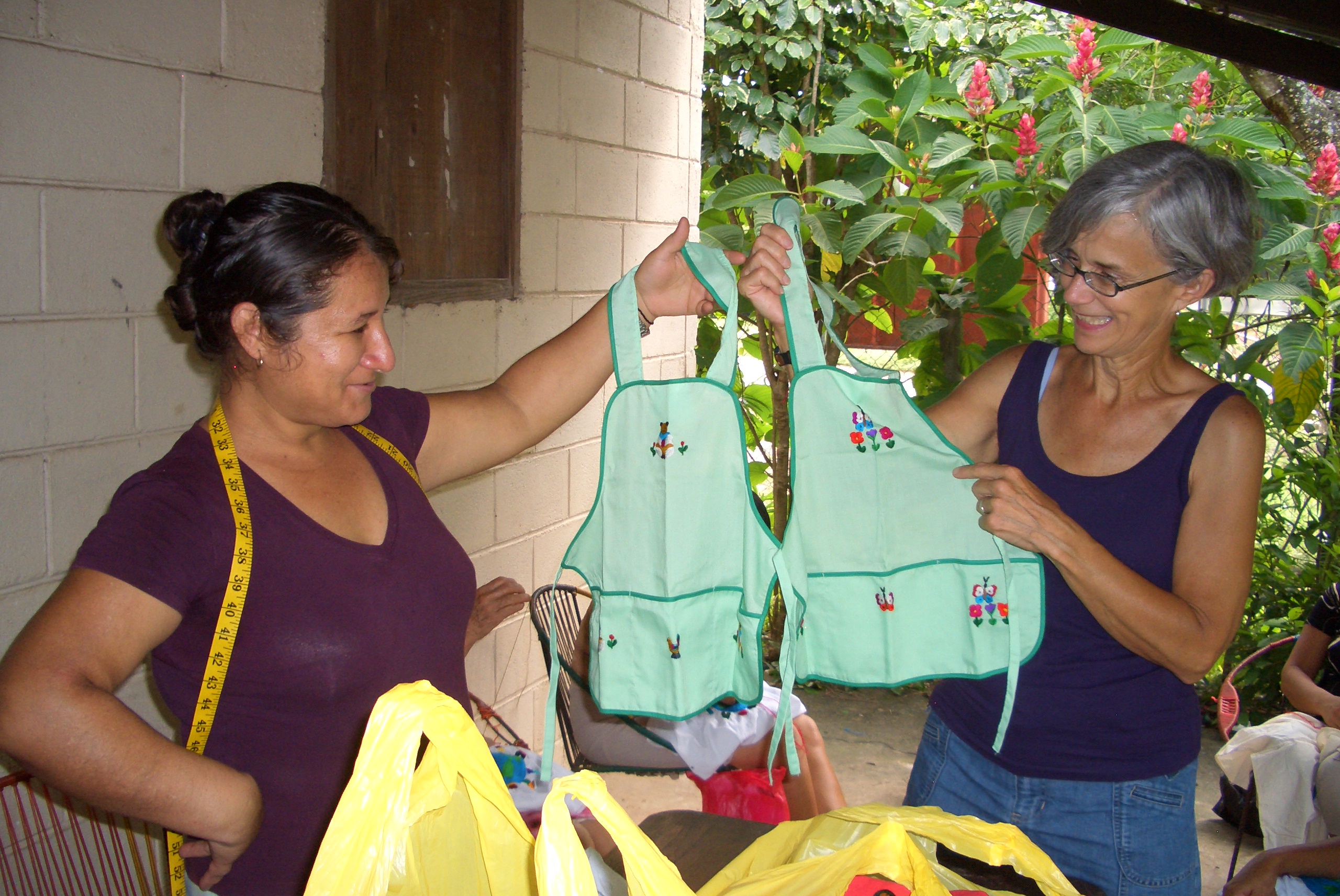 Women showing embroidered aprons
